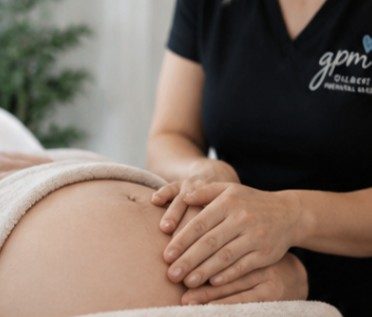 A Gilbert Prenatal Massage therapist's hands on an expecting mama's belly