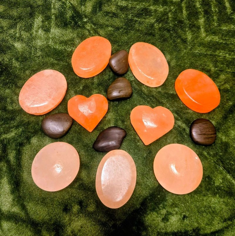 Himalayan salt stones and smooth basalt stones on a green throw