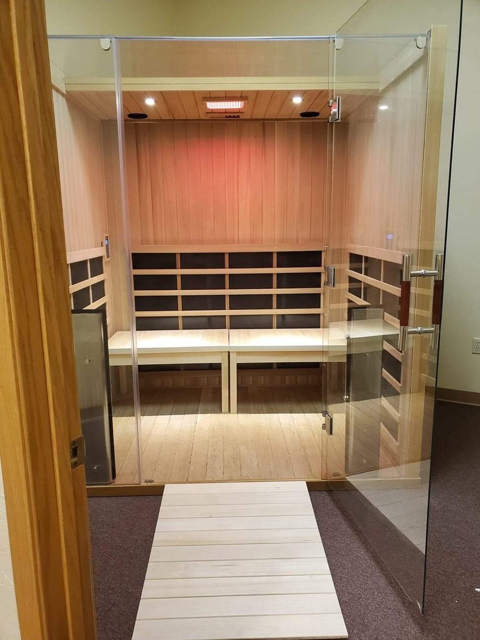 The full-spectrum infrared sauna at Blue Sage, cedar benches behind a glass door