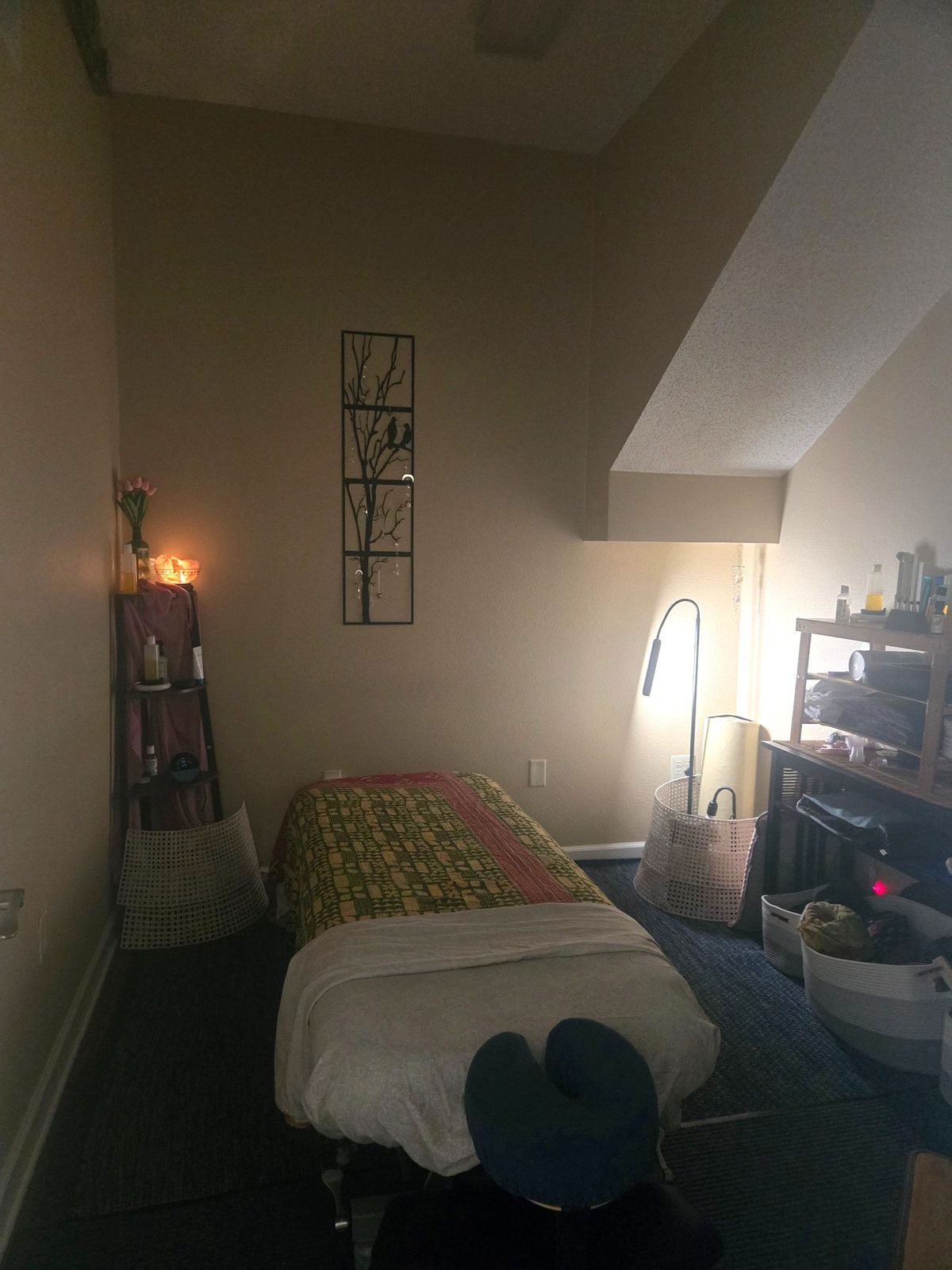 Sharon's treatment room at Blue Sage: the table under a patterned quilt, a salt lamp glowing on the shelf