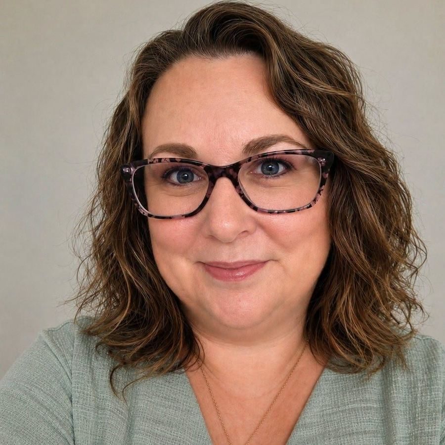 Chasity Nelson smiling, in glasses and a green top