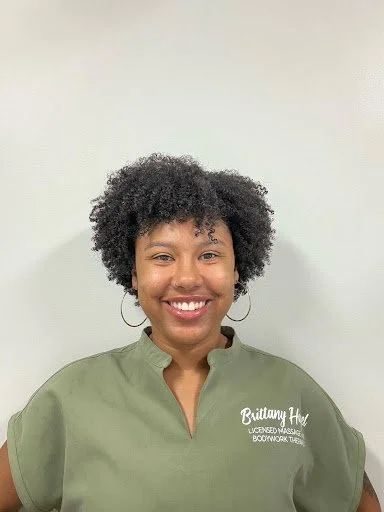 Brittany Hazel smiling, in a green Essence of Renewal top
