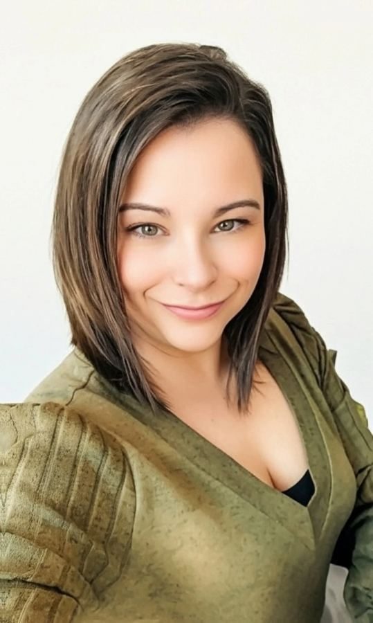 Katrina Braham smiling, in an olive sweater